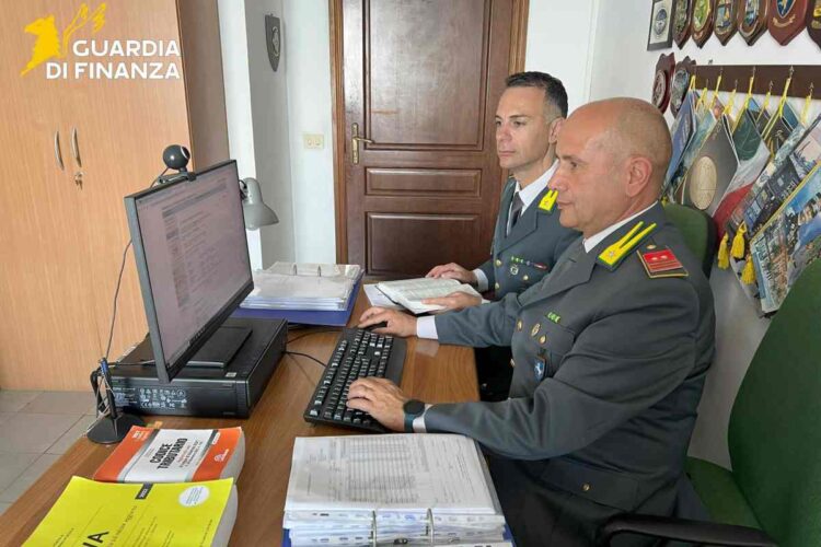 Agenti della Guardia di Finanza al lavoro al pc